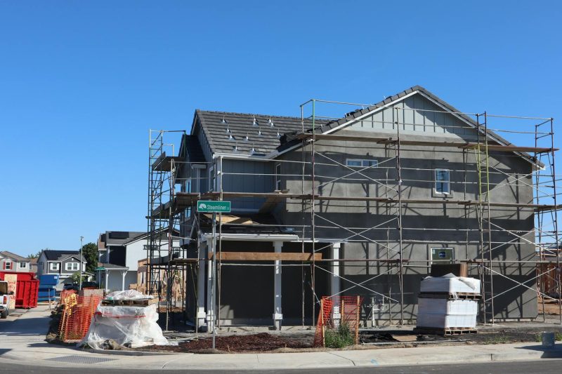 New housing development in Elk Grove, California, featuring scaffolding and construction materials.
