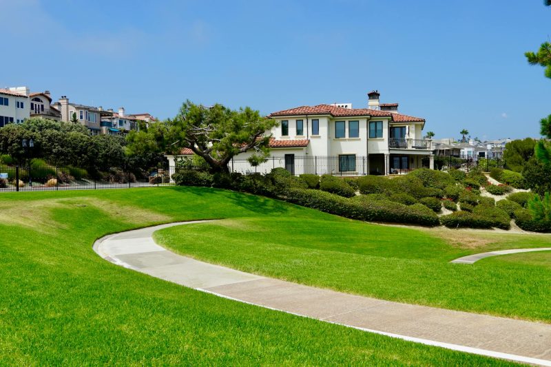 Picturesque suburban neighborhood featuring Mediterranean-style homes and lush green lawns.