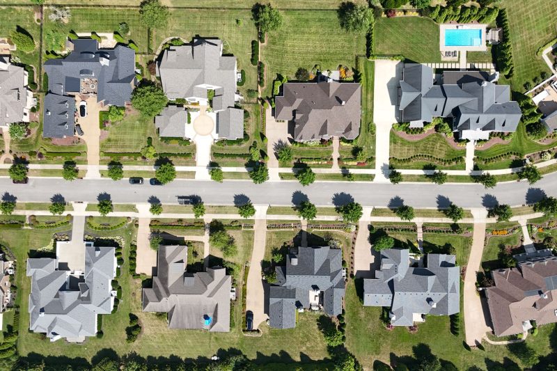 Overhead view of modern homes in a lush, green Tennessee suburb, surrounded by trees.