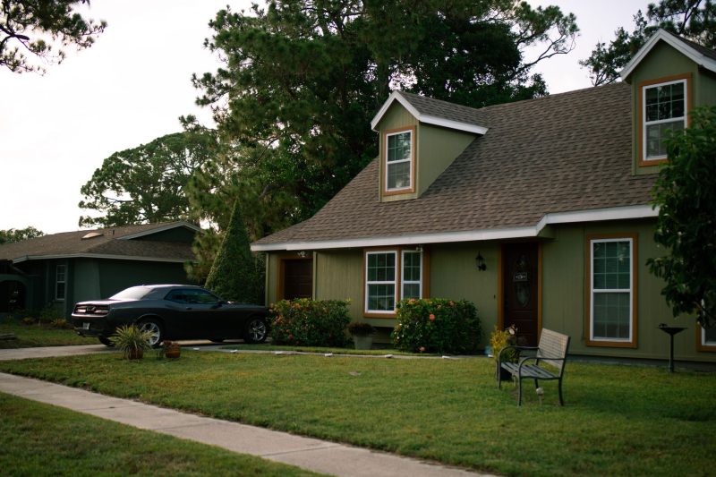 Suburban home with a manicured lawn and a parked car, showcasing residential comfort.